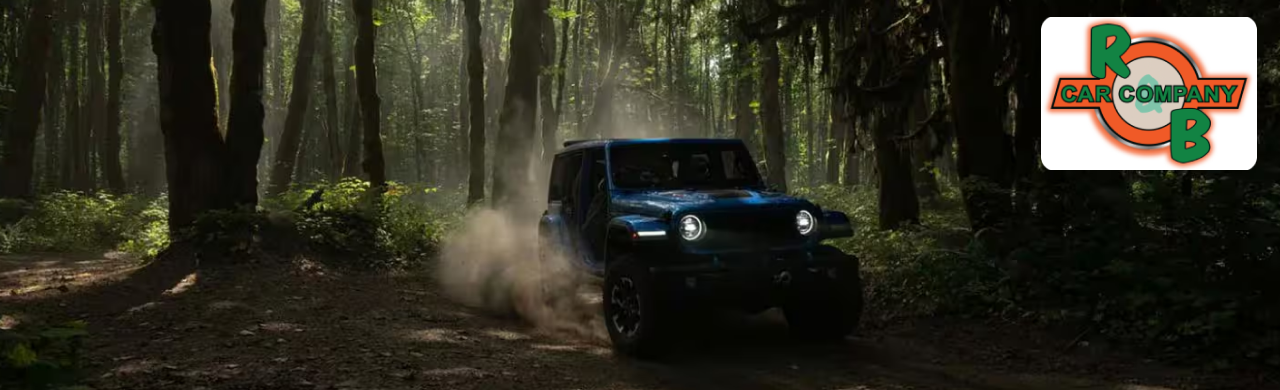 A photo of a blue Jeep Wrangler driving off-road through the woods.